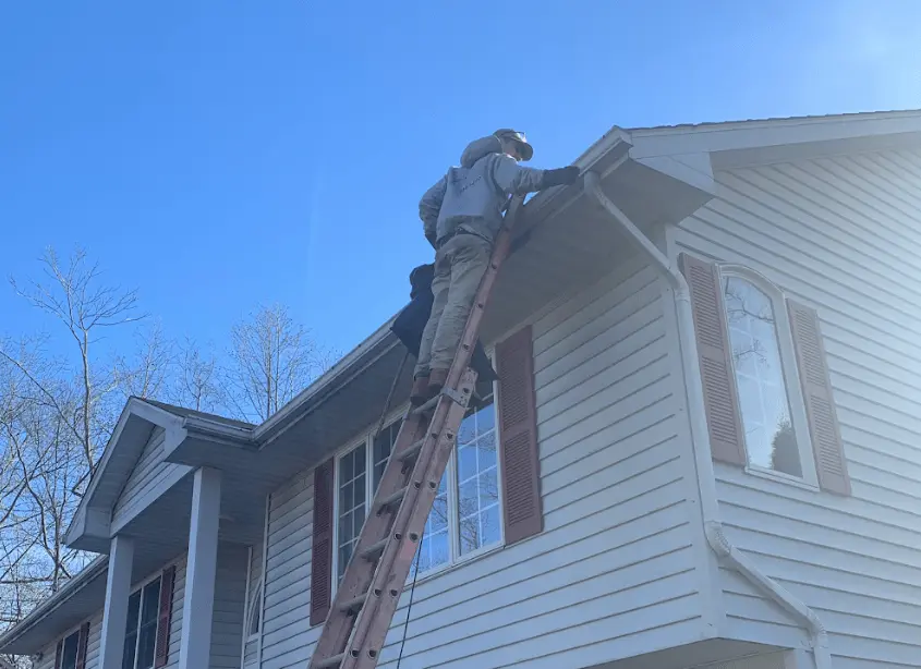 Gutter cleaning and maintenance being performed by Bedford Power Washing in Bedford